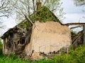 Old and collapsed country house, collapsed wall and old wooden logs