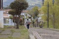 An old colombian gardener man walking down with his grass cutter machine into Guatavita town