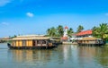 Old colonial Saint Thomas catholic church on the coast of Pamba river, with palms and anchored living houseboats, Alleppey, Kerala Royalty Free Stock Photo