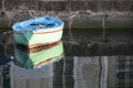 Old colored wooden boat in the water in a river with reflection