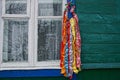 Colored wreath with ribbons hanging on the wall of a house by the window in the street