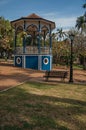 Old colorful gazebo and lighting pole in the middle of garden with green lawn, in a sunny day at SÃÂ£o Manuel.