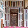 Old colorful marble wall with wooden door decorated with arabesque ornaments, Cairo, Egypt