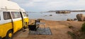 Old colorful retro camper van on camping site at beautiful rocky coastal landscape of Costa Smeralda, north east