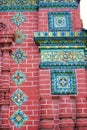Old colorful tiles on the red bricks wall of Epiphany church. Royalty Free Stock Photo