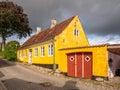 Old colorful yellow detached house with garage in old town of Mariager, Nordjylland, Denmark