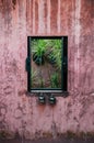 Old coloured concrete wall with wooden window frame in tropical Royalty Free Stock Photo