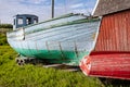 Old colourful red, green and blue fishing boats with peeling paint on land in Sisimiut, Greenland