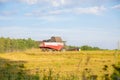 old combine harvester harvests from the field Royalty Free Stock Photo