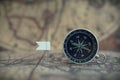 Old compass and flag marking pins on blur vintage map background, journey planning concept