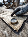 Old compass and hand on vintage map, nautical exploration theme. Royalty Free Stock Photo