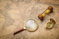 Old compass , magnifying glass and sand clock  on vintage map Royalty Free Stock Photo