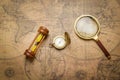 Old compass , magnifying glass and sand clock  on vintage map Royalty Free Stock Photo
