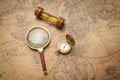 Old compass , magnifying glass and sand clock  on vintage map Royalty Free Stock Photo