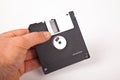 Old computer and data storage technology, hand held black magnetic floppy disk 3ÃÂ½ inches, isolated on white background Royalty Free Stock Photo