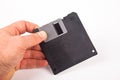 Old computer and data storage technology, hand heldblack magnetic floppy disk 3ÃÂ½ inches, isolated on white background Royalty Free Stock Photo