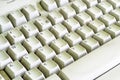 Old computer keyboard, once white, with dust between the keys. Diagonal pattern of letters on a PC keyboard. Royalty Free Stock Photo