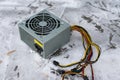 An old computer power supply discarded in the snow in winter Royalty Free Stock Photo