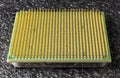 Old computer processor with gold-plated legs, on a black soft backing