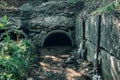 Old concrete drainage pipes with flowing wastewater, sewage or sewerage tunnel tube with water stream