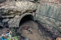 Old concrete drainage pipes with flowing wastewater, sewage or sewerage tunnel tube with water stream