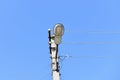 Old concrete electric pole for transmission of wired electricity with lamp post on a background of a cloudy blue sky. Obsolete me Royalty Free Stock Photo