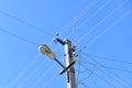 Old concrete electric pole for transmission of wired electricity with lamp post on a background of a cloudy blue sky. Obsolete me Royalty Free Stock Photo