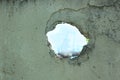 Old Concrete fence with hole on blue sky view. Wall with broken tiles, use as horror scene, background for breaking news