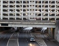 Old concrete multistory car park build over an underpass on an inner city ring road with traffic in leeds center