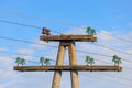 Old concrete power line support with insulators and wires against blue sky Royalty Free Stock Photo