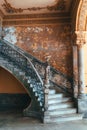 Old concrete shabby rounded staircase with a statue in an old Spanish-style colonial house Royalty Free Stock Photo