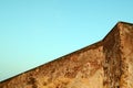 Old concrete wall of brown color against the blue sky. The geometry of the building. Abstract architecture. Royalty Free Stock Photo