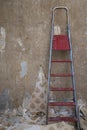 Old concrete wall with removed wallpaper and a ladder