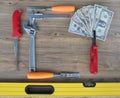 Old construction tools and a set of dollar bills on a wooden table close-up Royalty Free Stock Photo