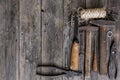 Old construction tools hammer, pliers, screwdriver, chisel lie on aged wooden boards of dark color with expressive texture