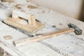 Old construction tools for plaster on vintage wood bench. Trowels and other masonry tools. Copy, empty space for text