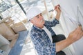 Old construction worker measuring wall Royalty Free Stock Photo