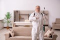 Old male contractor doing pest control at home Royalty Free Stock Photo