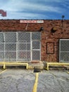 Old Red Brick Storefront Exterior Wall and Vintage Arrow Shaped Sign.