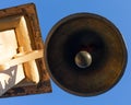 Old copper bell on a wooden pillar bottom view, signal bell. Outdated device for warning and gathering people, alarm. Beautiful