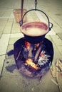 old copper cauldron with fire made from logs