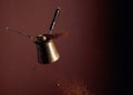 Old copper coffee maker and a spoon with ground coffee in motion Royalty Free Stock Photo