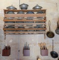 Old copper kitchenware stands on the wooden shelf on the wall Royalty Free Stock Photo