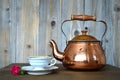 Old copper teapot and porcelain teacup Royalty Free Stock Photo