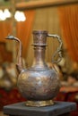 Old copper water ewer over yellow background