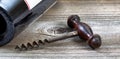 Old corkscrew and wine bottle in background on rustic wood Royalty Free Stock Photo