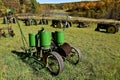 Old corn planter surrounded by retro John Deere tractors Royalty Free Stock Photo