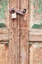 Old and corroded wooden double door closed with padlock