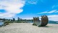 Old corten steel arc sculpture on the beach in Vancouver, Canada, in blue sky background