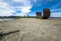 Old corten steel arc sculpture on the beach in Vancouver, Canada, in blue sky background